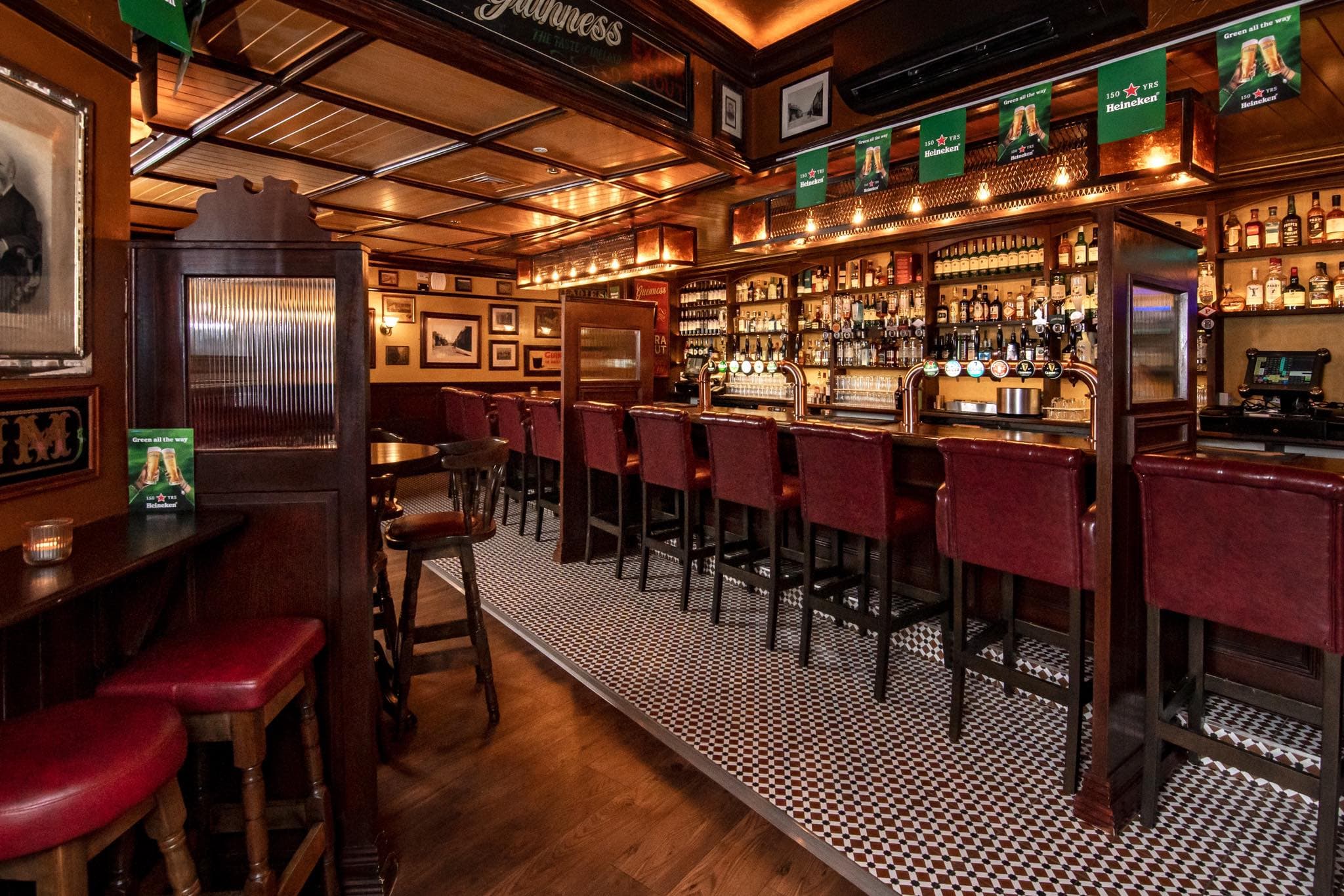 The Coachman's Inn bar — copper-panelled ceiling, leather bar stools and a well-stocked back bar
